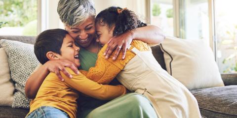 a mother hugging her two children on the couch