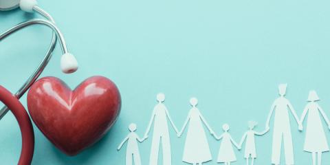 a paper cutout of family members next to a heart and stethoscope